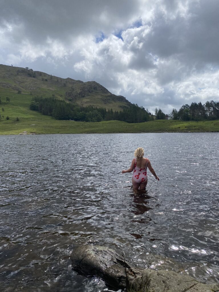 Kerry in the middle of lake with mountains in the background